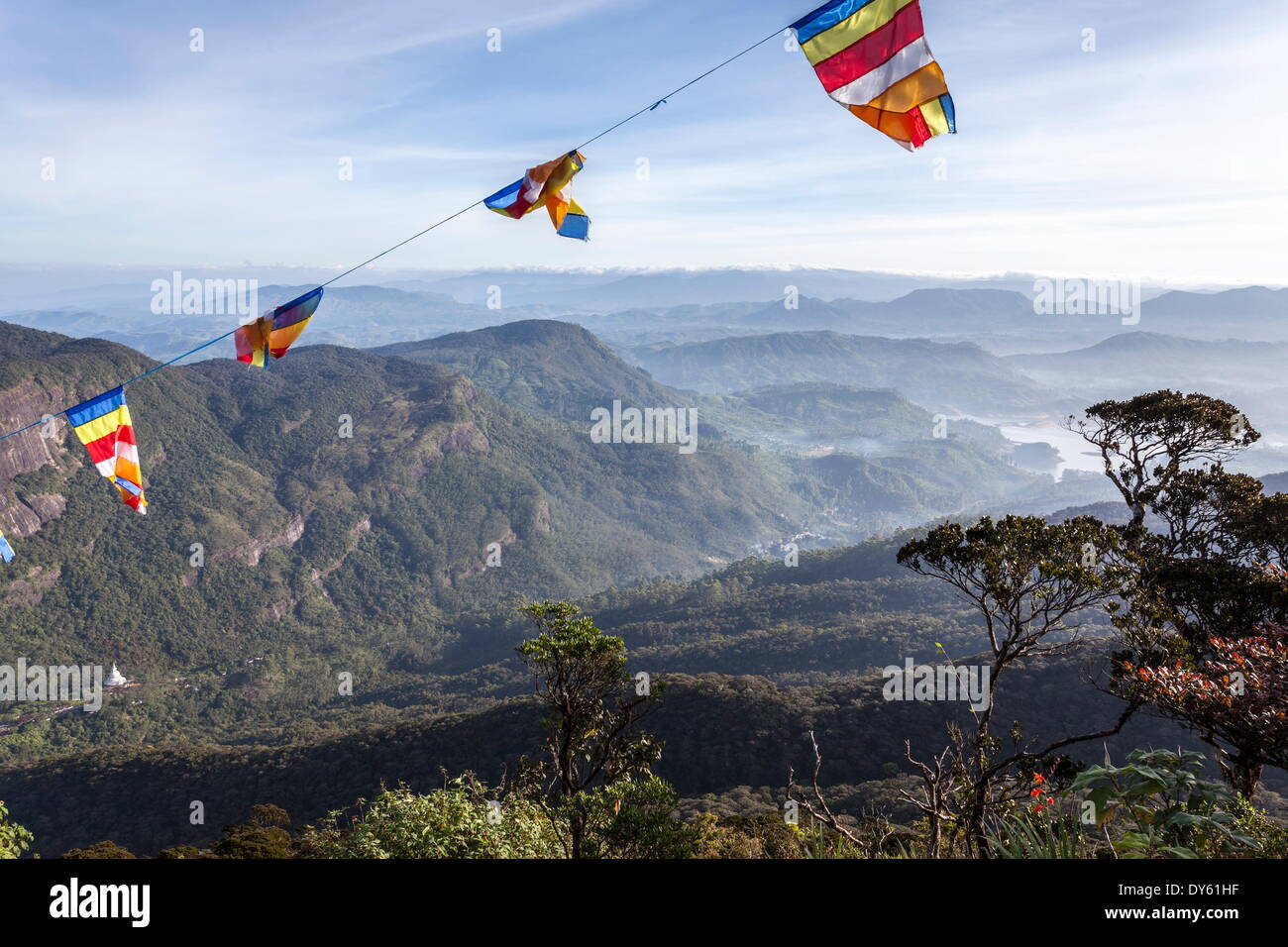 Buddhist flags framing the view to Dalhousie and the Hill Country beyond at sunrise from Adam's Peak (Sri Pada), Sri Lanka Stock Photo