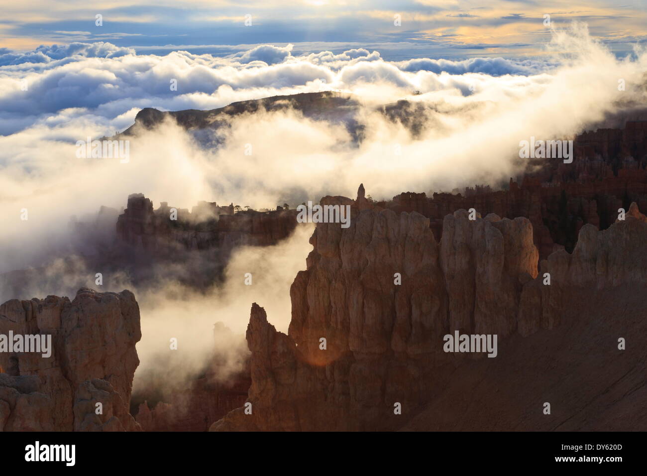 Fog and clouds of a partial temperature inversion surround the red rocks of Bryce Canyon, Bryce Canyon National Park, Utah, USA Stock Photo