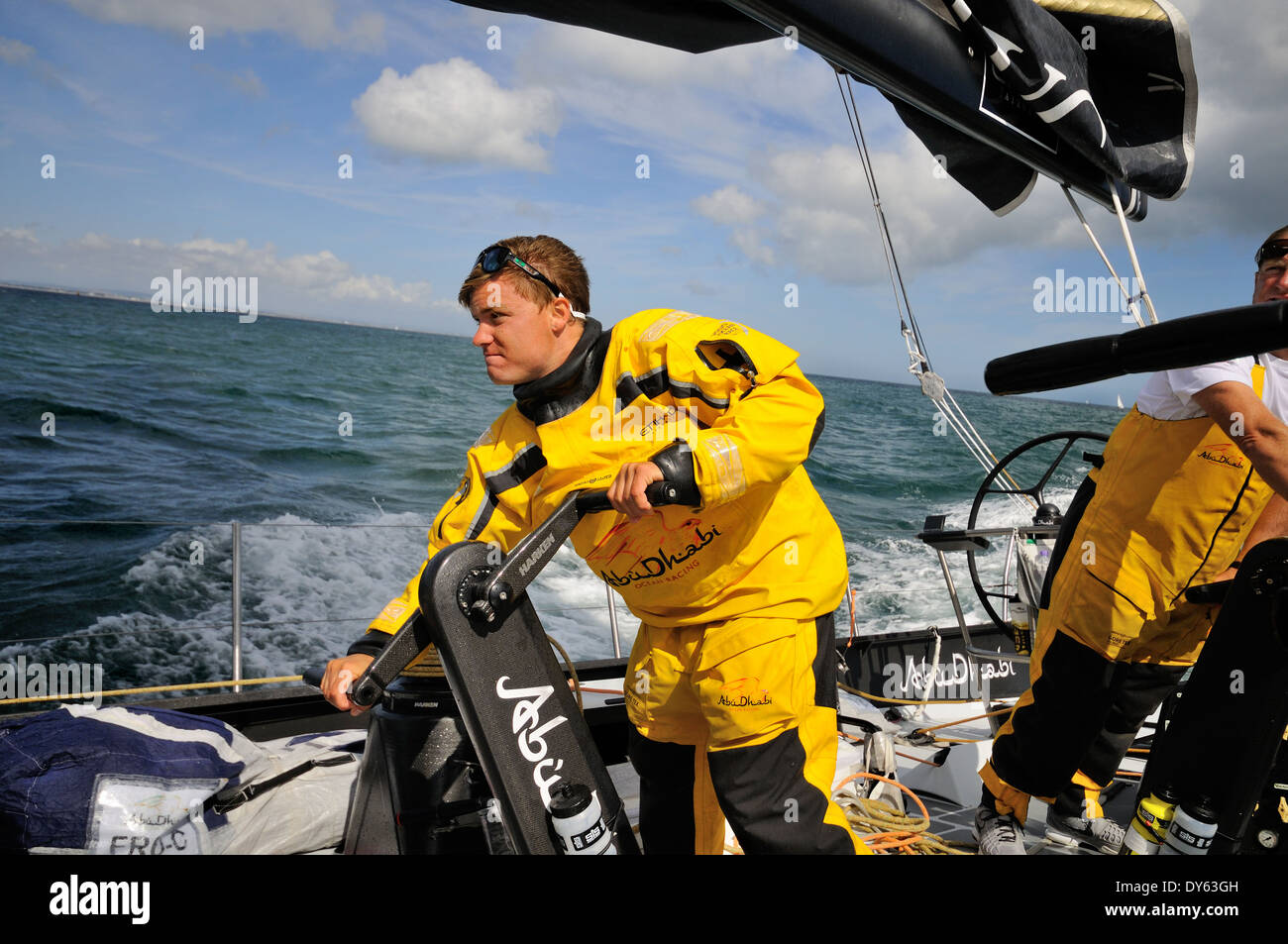 Crewman in full weather gear winch grinding aboard ocean racing yacht Stock Photo