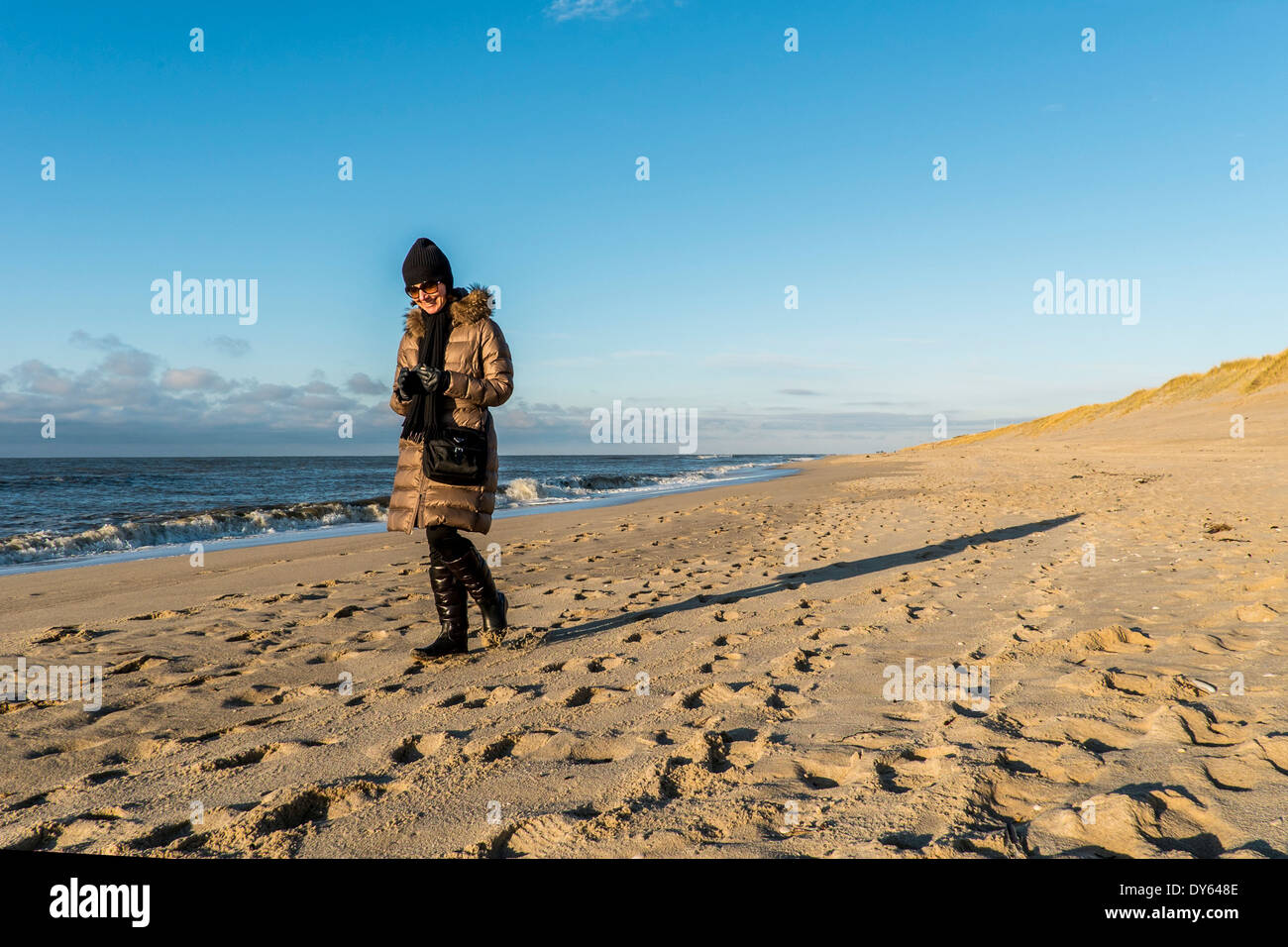 Woman walking along a beach in winter, Sylt, Schleswig-Holstein, Germany Stock Photo