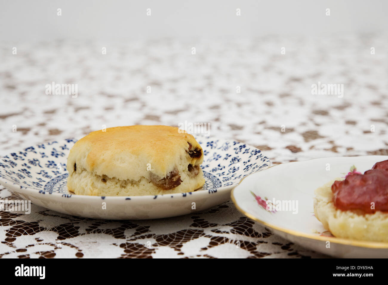 English Afternoon tea. Vintage plates with Scones and Jam on a flora tablecloth Stock Photo