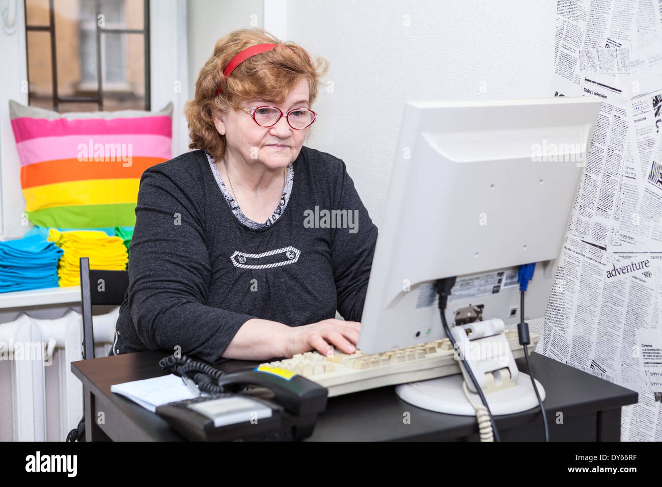 Senior woman typing keyboard button on computer Stock Photo