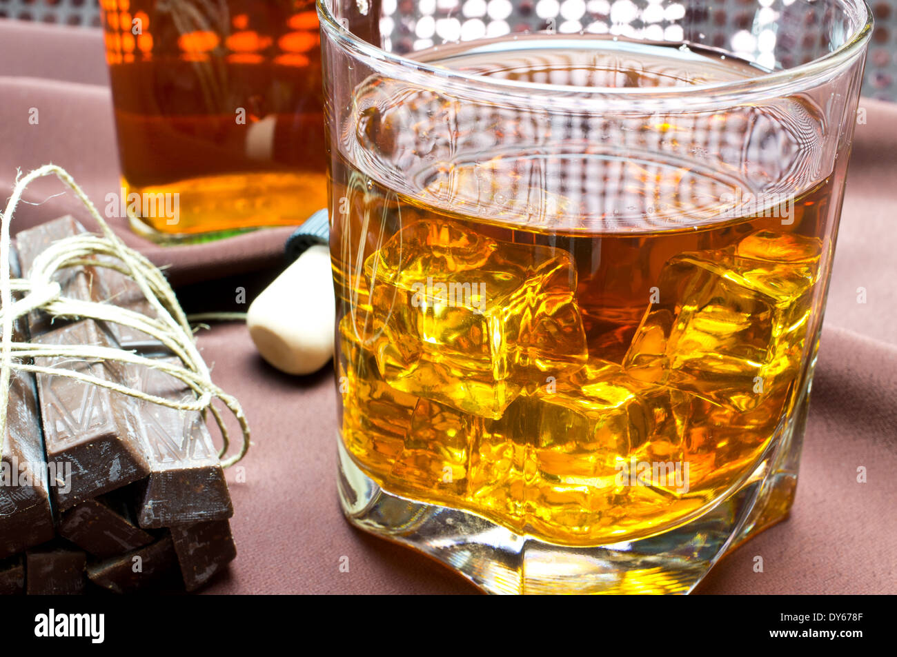 Whiskey in the glass, chocolates, a bottle, the cork Stock Photo