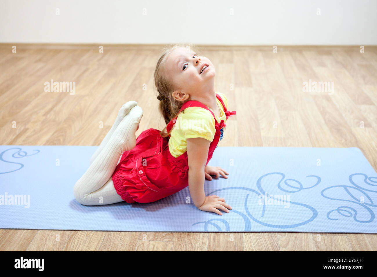 Pretty girl making yoga poses on mat in gym Stock Photo - Alamy