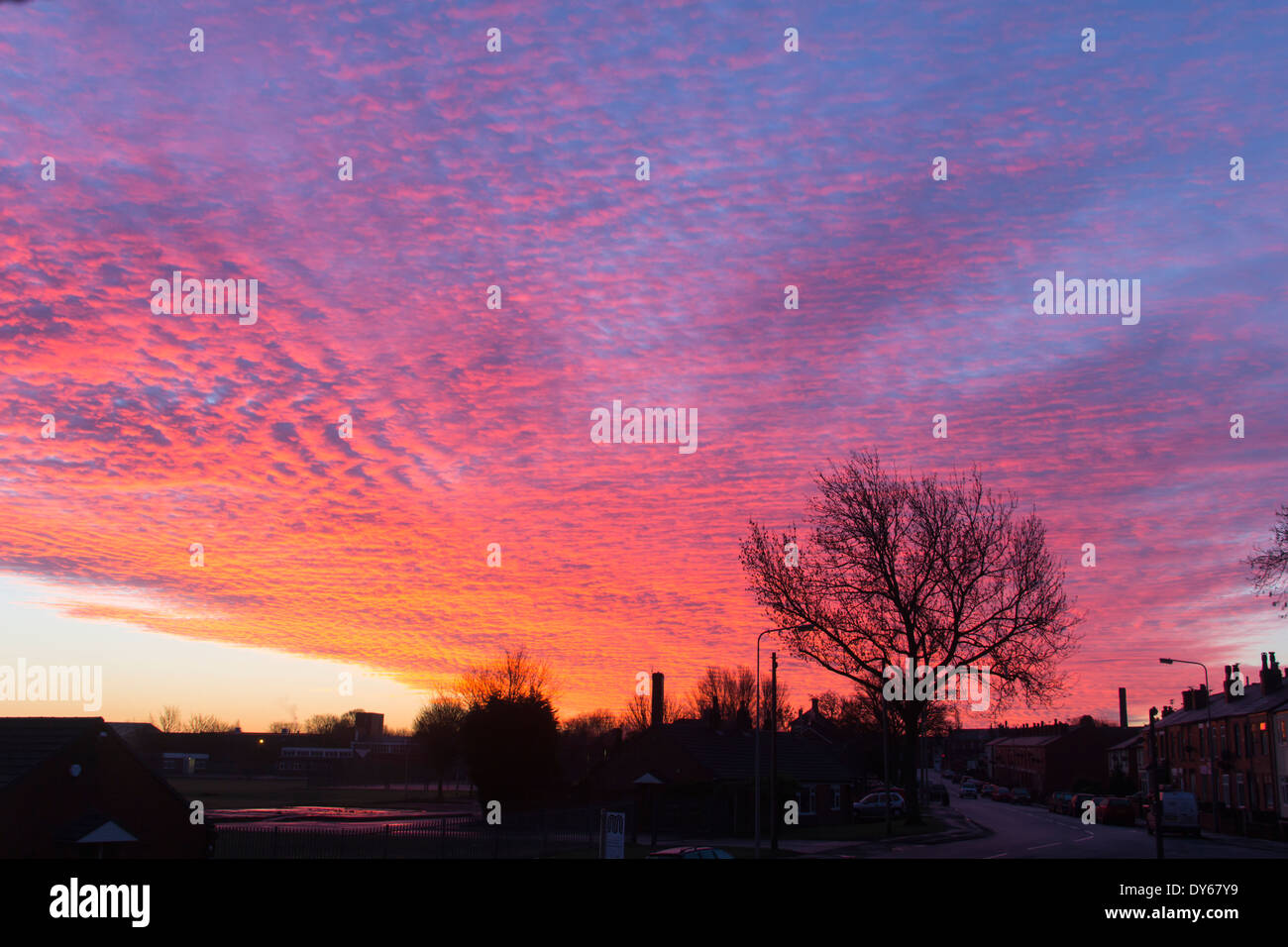 Red mackerel sky cloud formation at first light on a winter's day over urban northern England, Farnworth Lancashire. Stock Photo