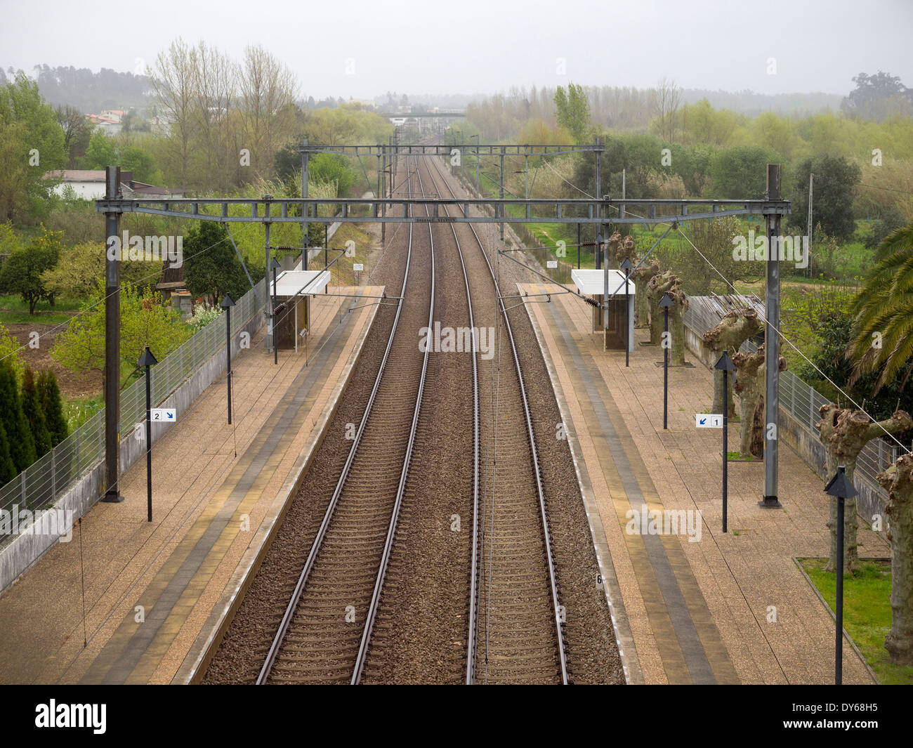 Empty train station platform and railroad tracks viewed from above Stock Photo