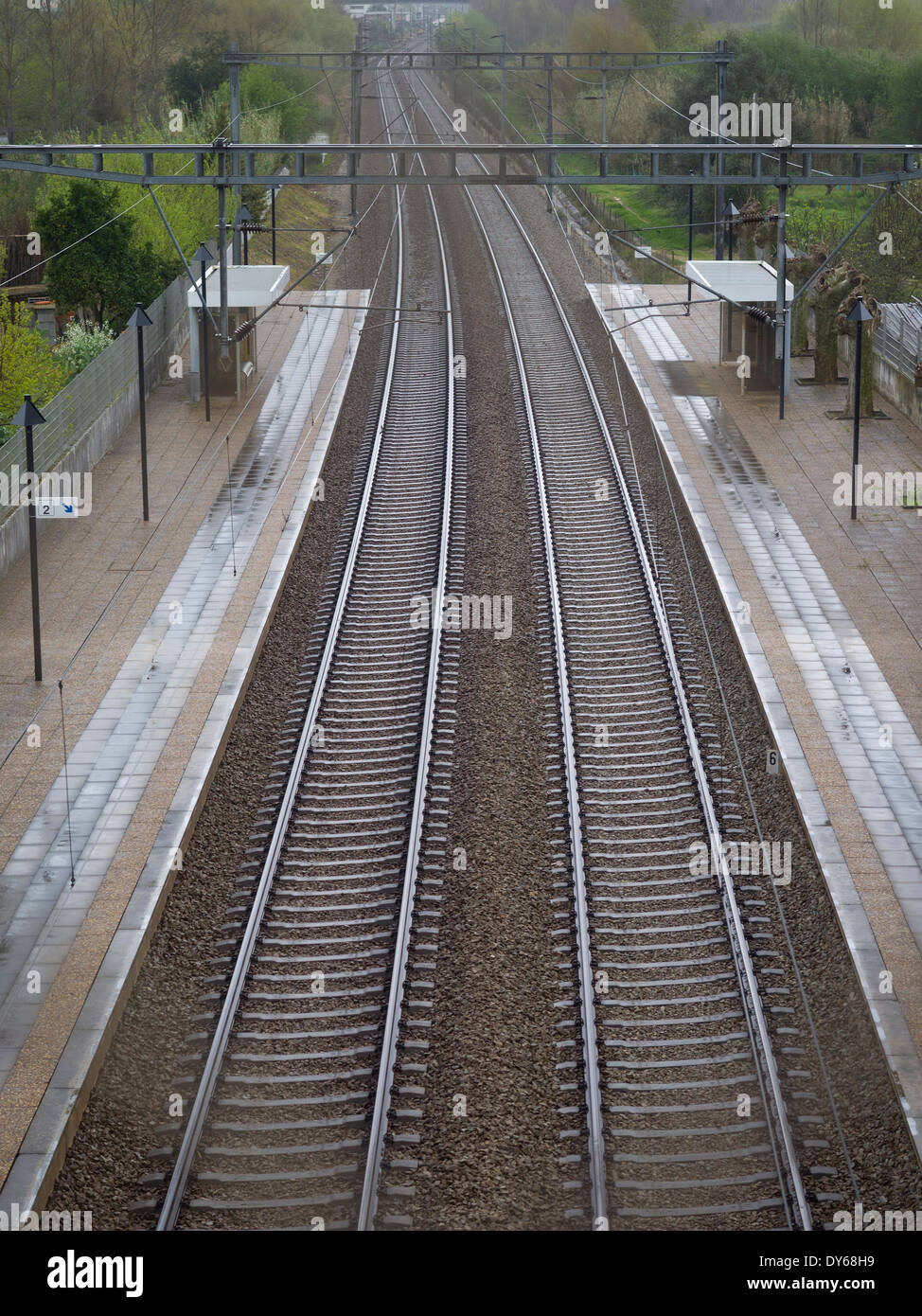 Empty train station platform and railroad tracks viewed from above Stock Photo