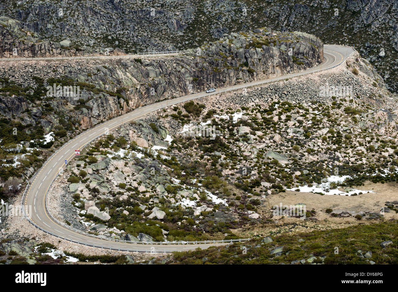 Aerial view of a car driving on a winding mountain road Stock Photo