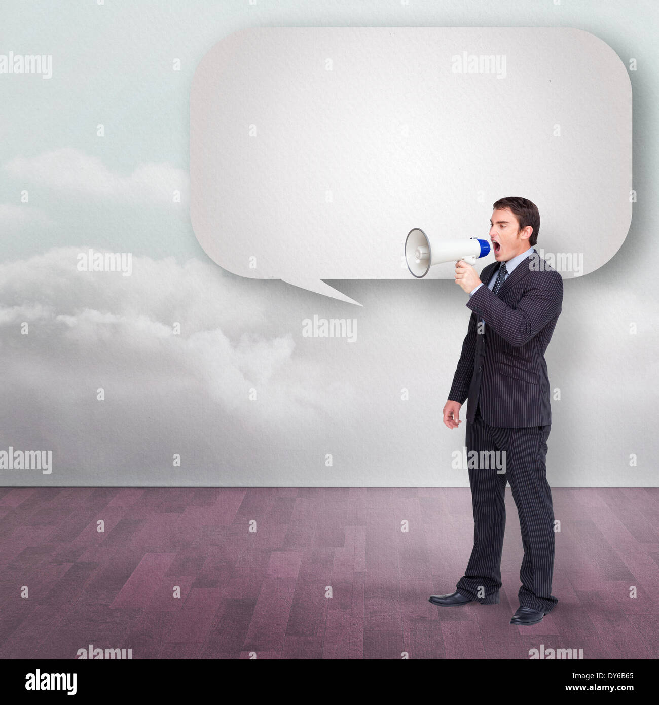 Standing businessman shouting through a megaphone with speech bubble Stock Photo