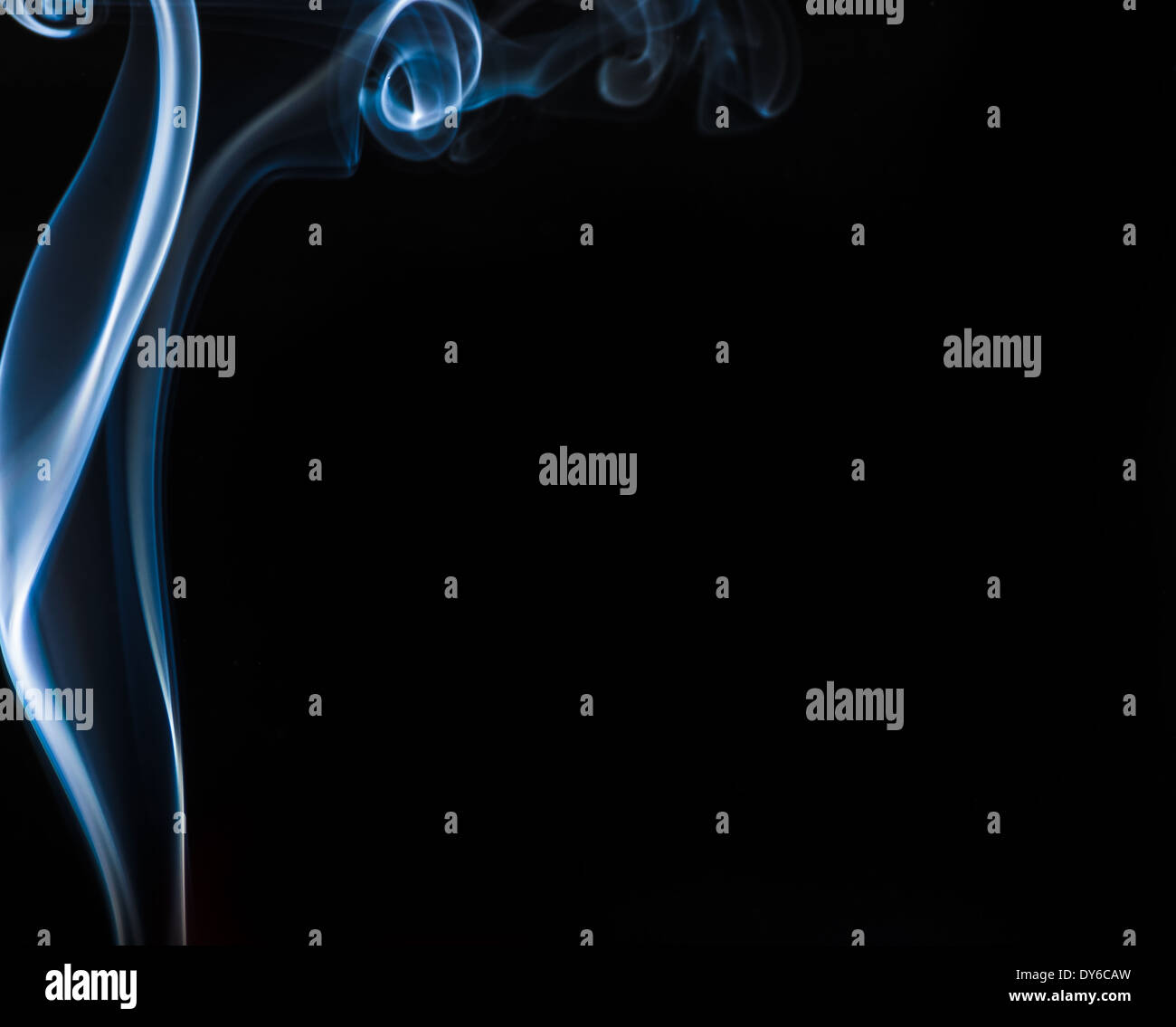 Flowing blue smoke frames a black backdrop Stock Photo