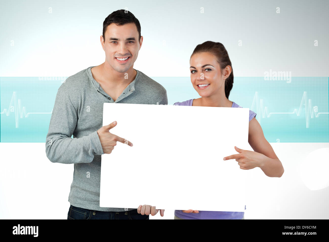 Composite image of attractive young couple showing card Stock Photo - Alamy