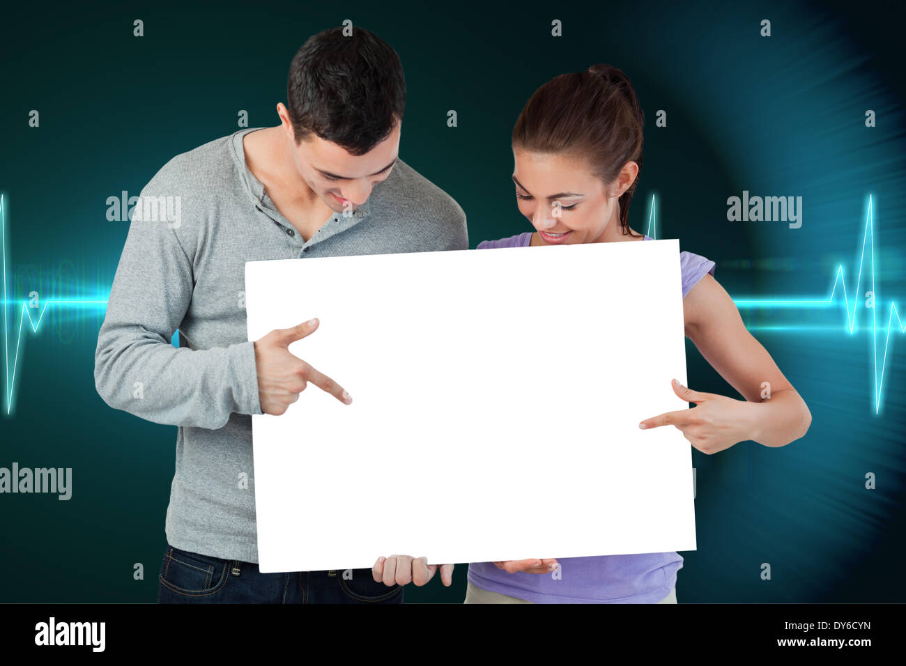 Composite image of attractive young couple showing card Stock Photo - Alamy