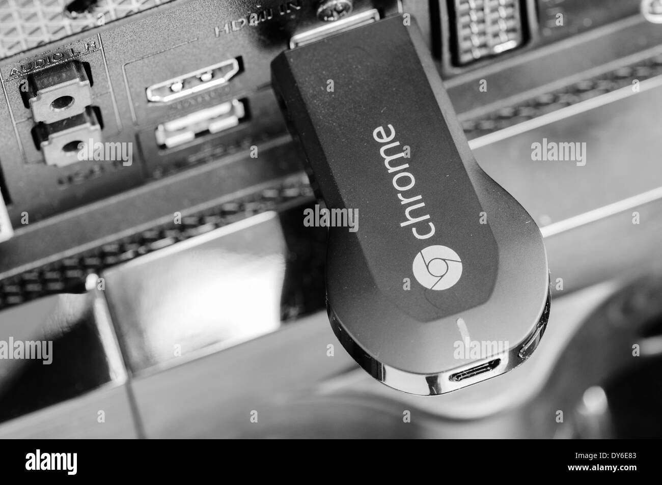 Google Chromecast TV streaming device plugged into the HDMI port of a television Stock Photo