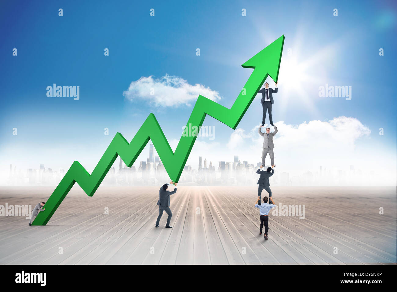 Composite image of business team holding up arrow Stock Photo
