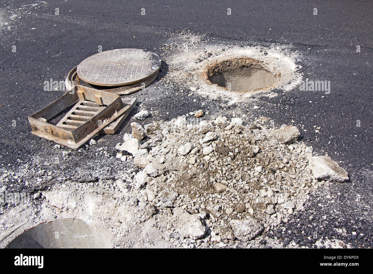 Open unsecured sewer manhole in the street Stock Photo