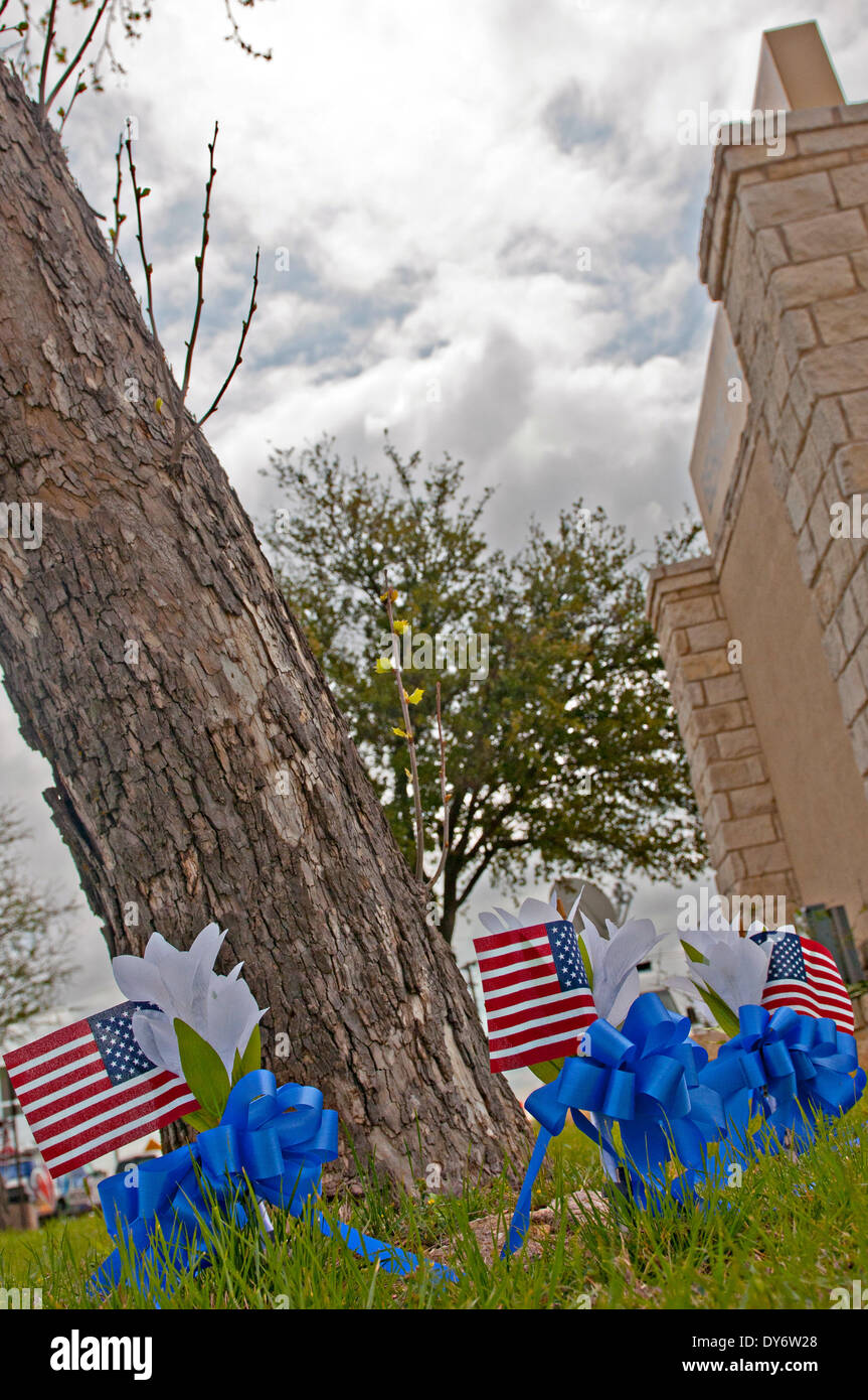A makeshift memorial of small flags and crosses supporting the victims of the April 2 shooting next to the Fort Hood main gate April 7, 2014 in Fort Hood, Texas. Stock Photo