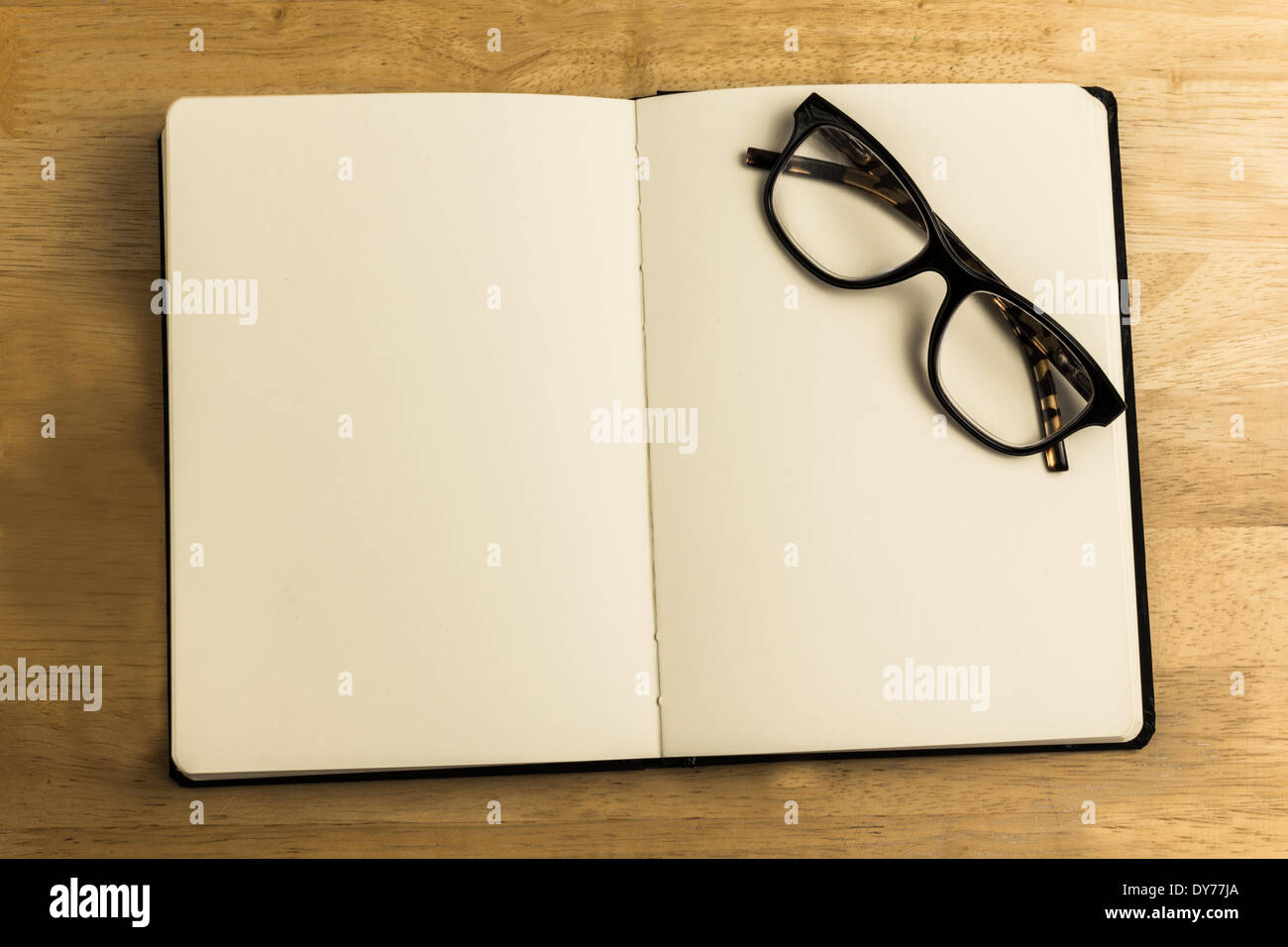Overhead of reading glasses with notebook Stock Photo