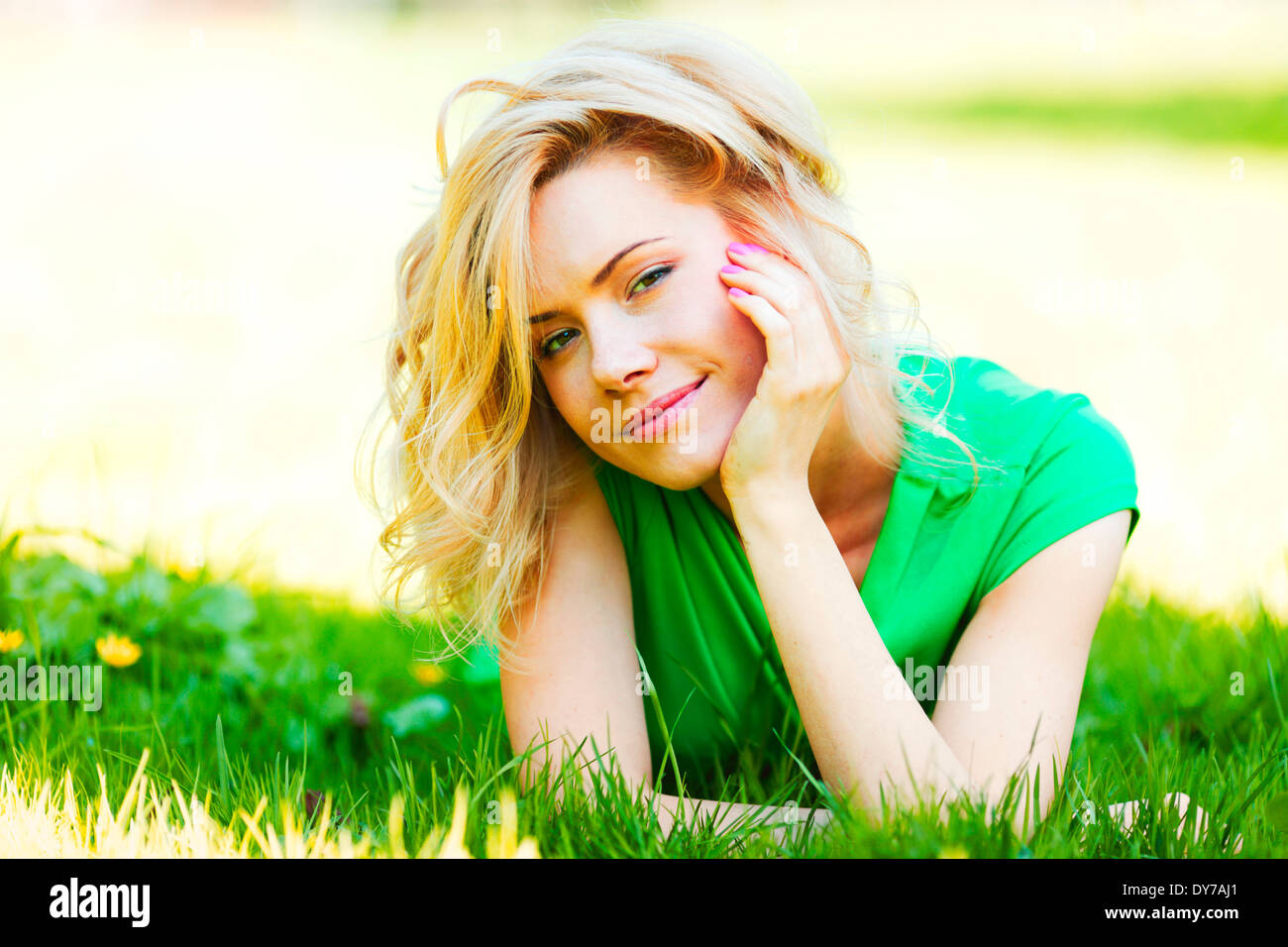 Happy young woman lying on grass Stock Photo - Alamy