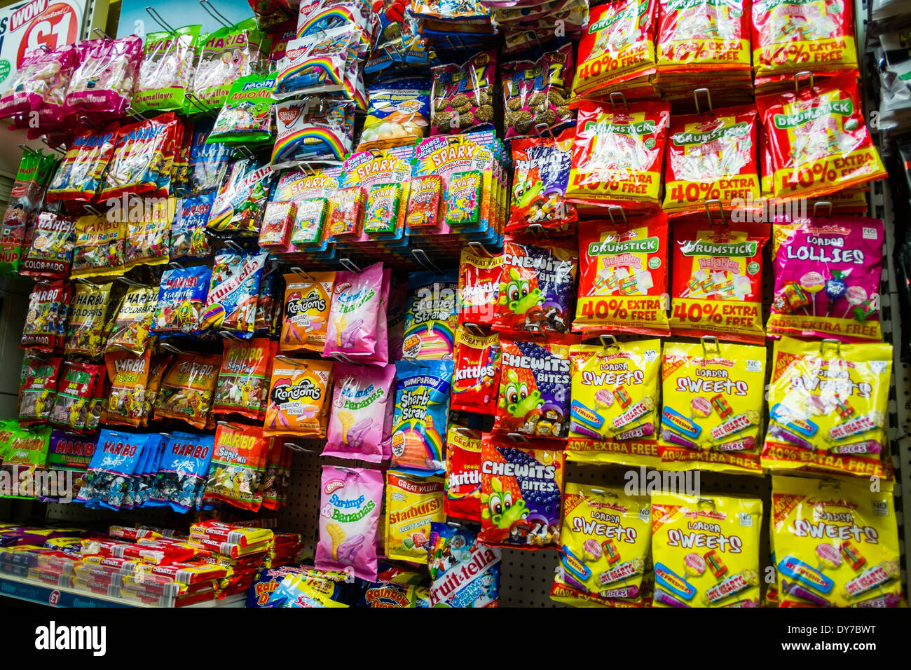 Packets of sweets candy on sale at child eye level in a supermarket shop store UK Stock Photo
