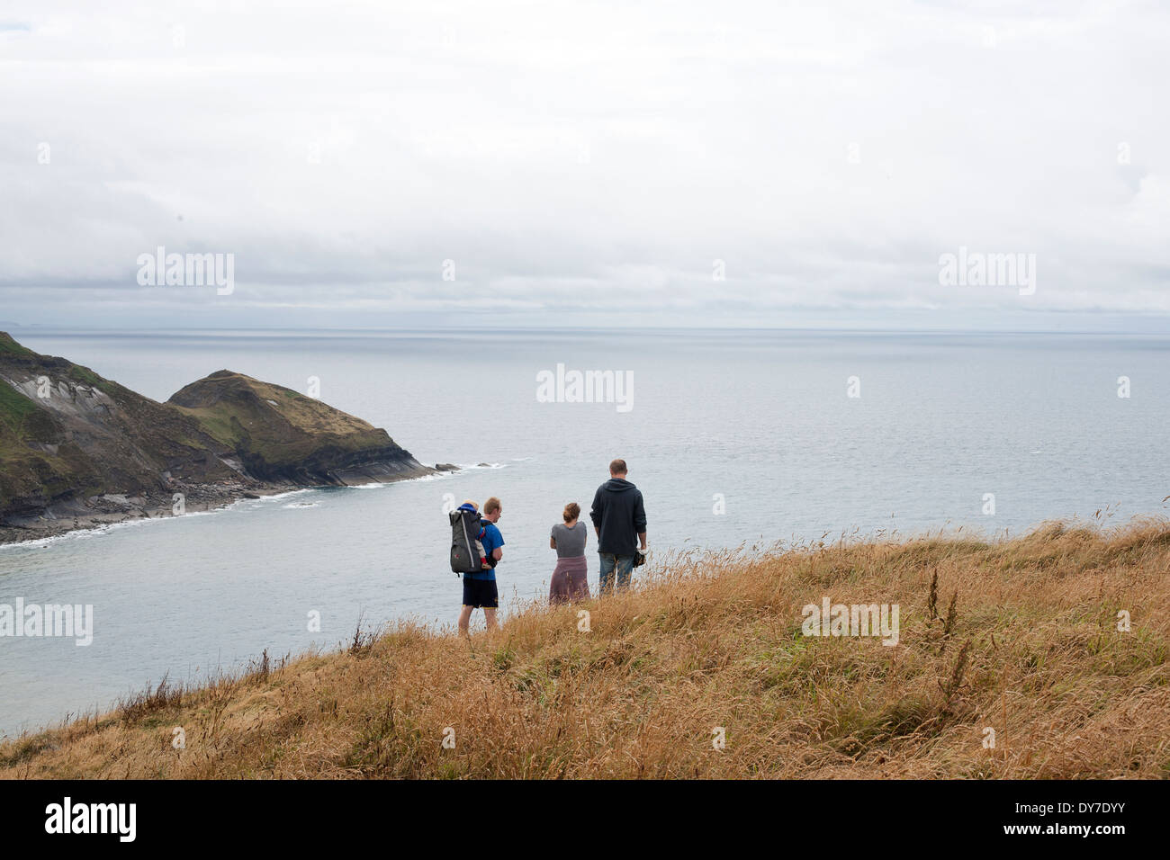 A group enjoy a walk on Penkenna above the sea at Crackington Haven in Cornwall Stock Photo