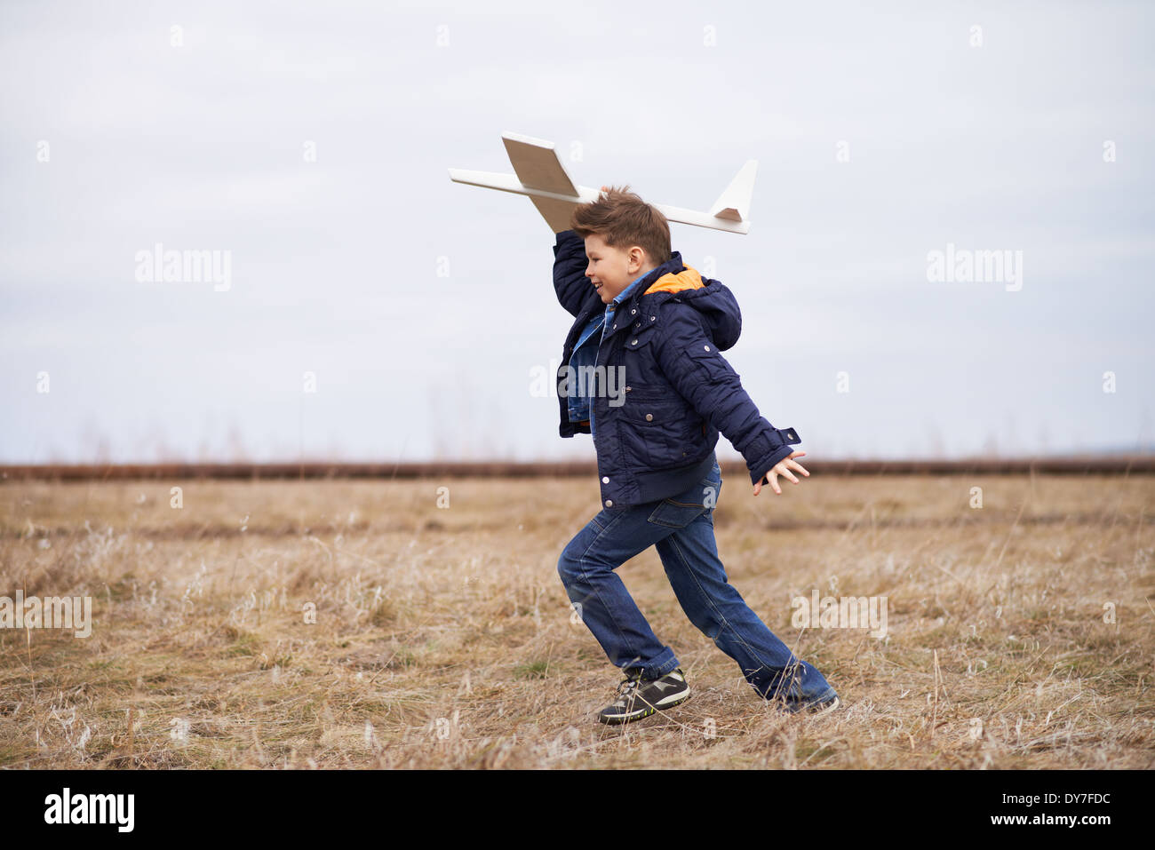 Photo of happy kid playing with toy airplane outside Stock Photo - Alamy