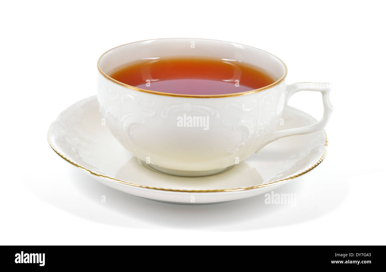 Tea in antique porcelain cup isolated on white background. Porcelain cup and saucer with delicate relief structures. Stock Photo