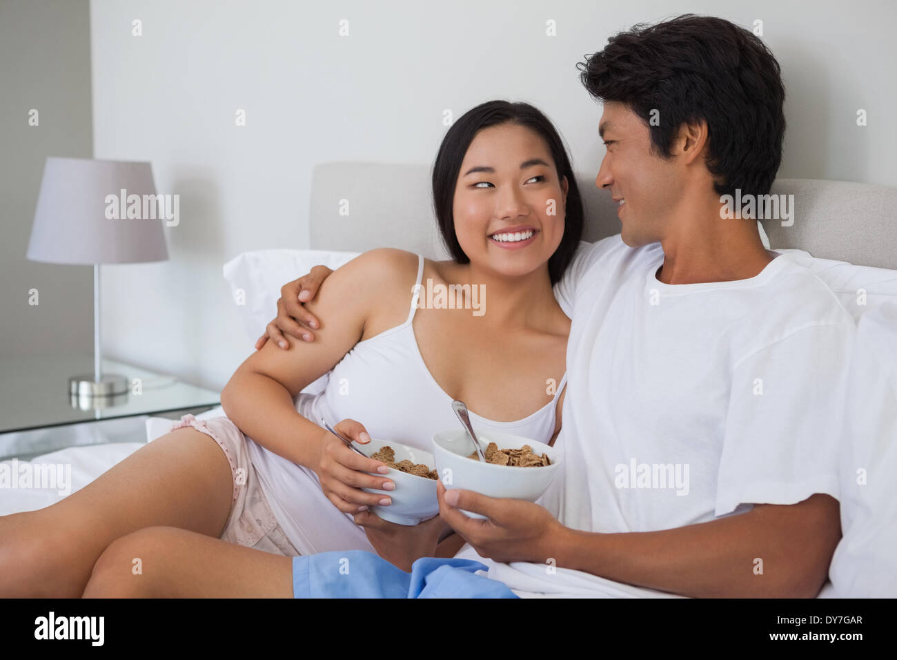 Happy couple having breakfast in bed Stock Photo