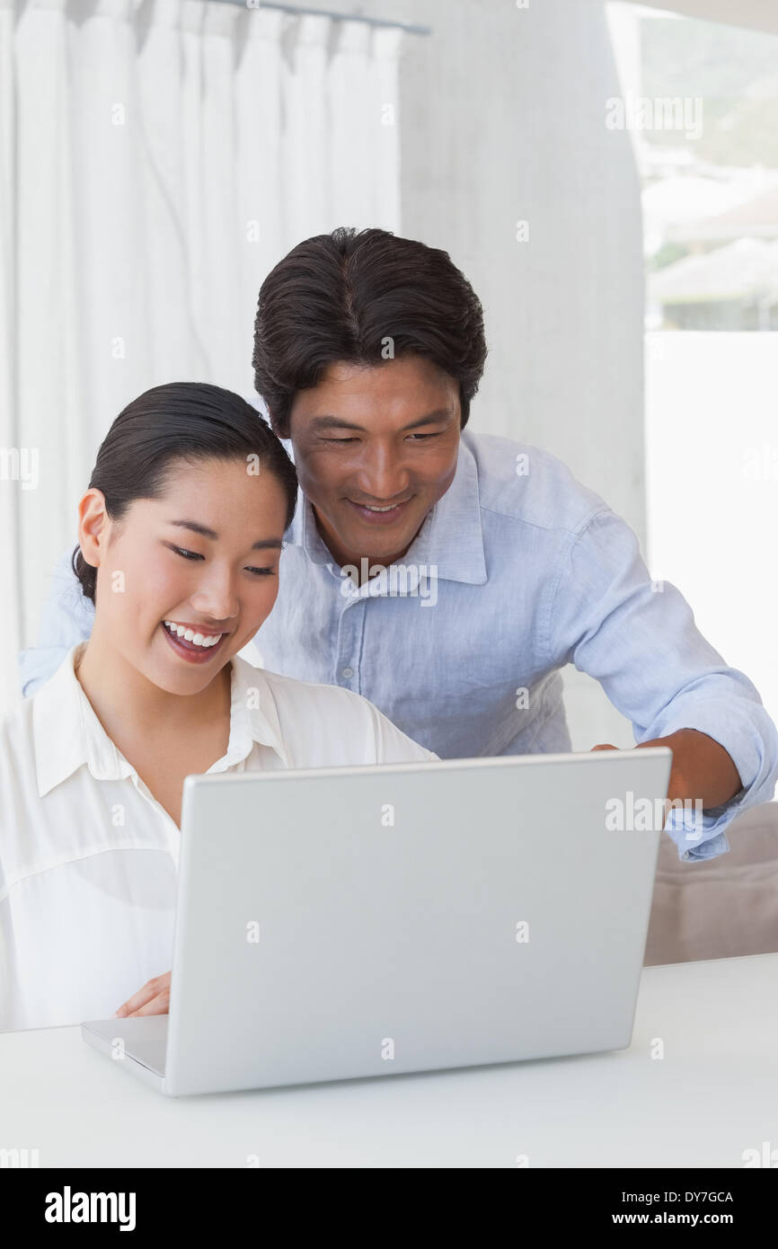 Happy couple using laptop together Stock Photo