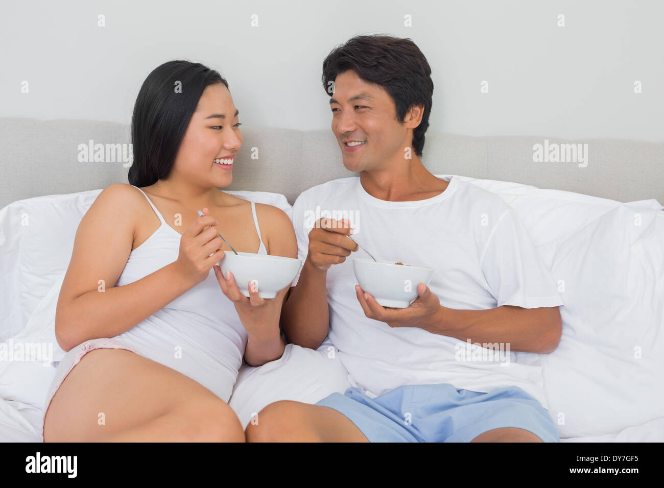 Happy couple having breakfast in bed Stock Photo