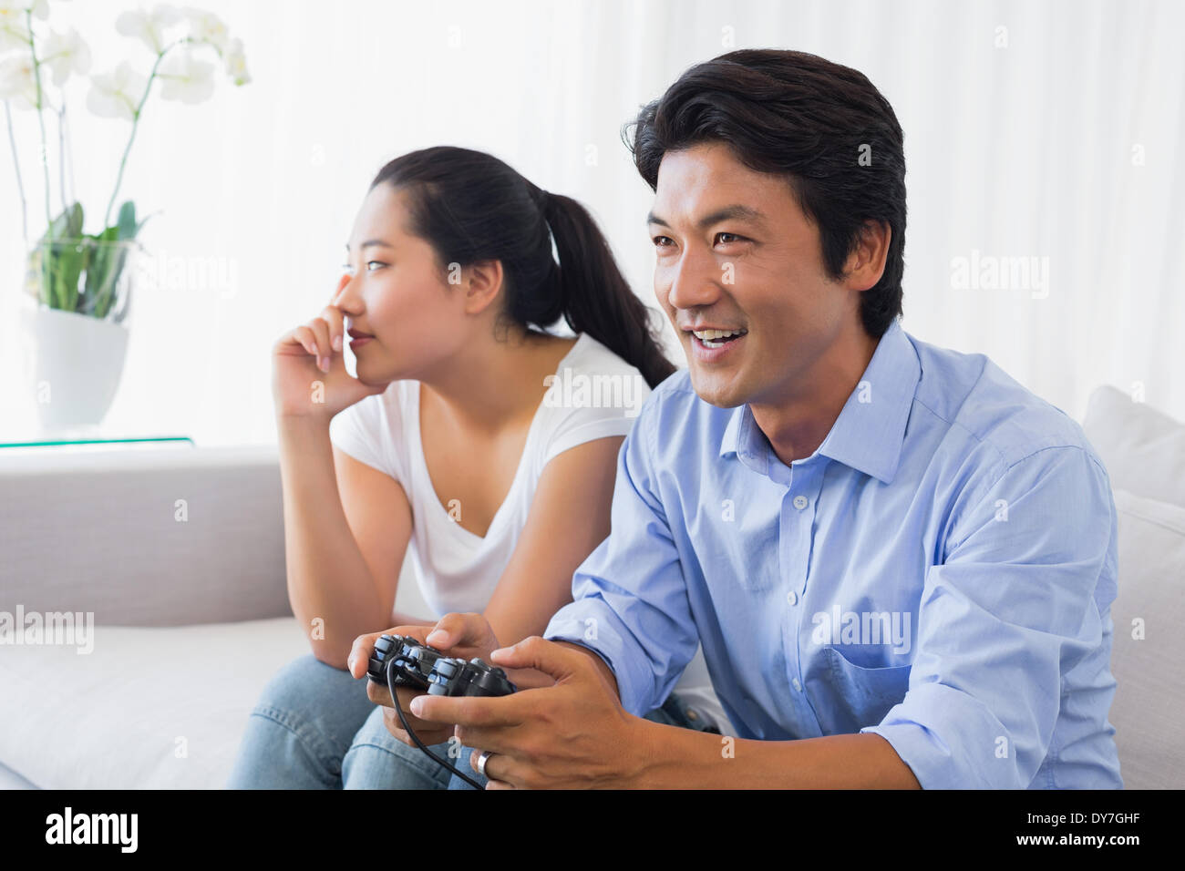 Woman being ignored by boyfriend playing video games Stock Photo - Alamy