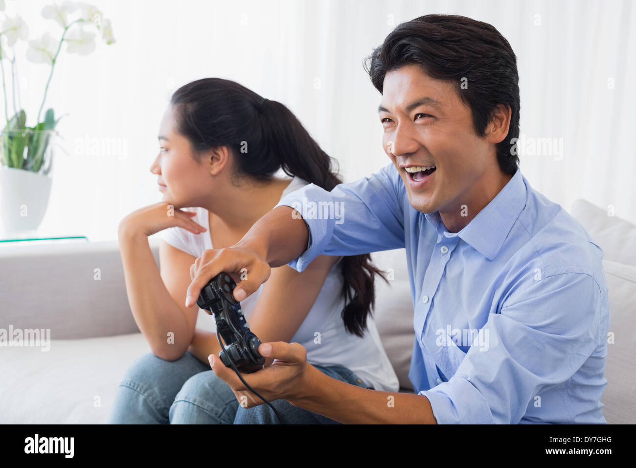Woman being ignored by boyfriend playing video games Stock Photo - Alamy