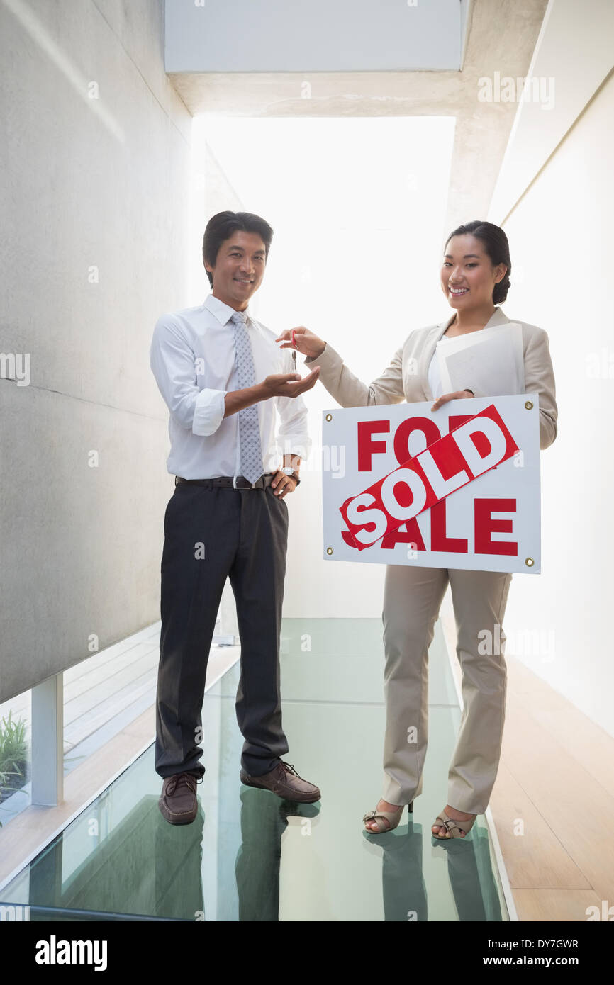 Estate agent giving keys to new home owner Stock Photo Alamy