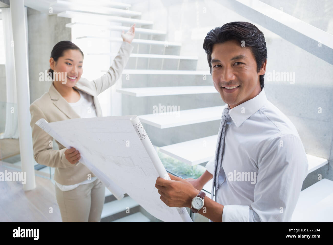 Estate agent showing stairs to potential buyer Stock Photo