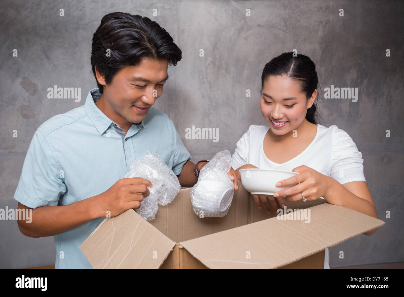 Happy couple unpacking moving boxes Stock Photo