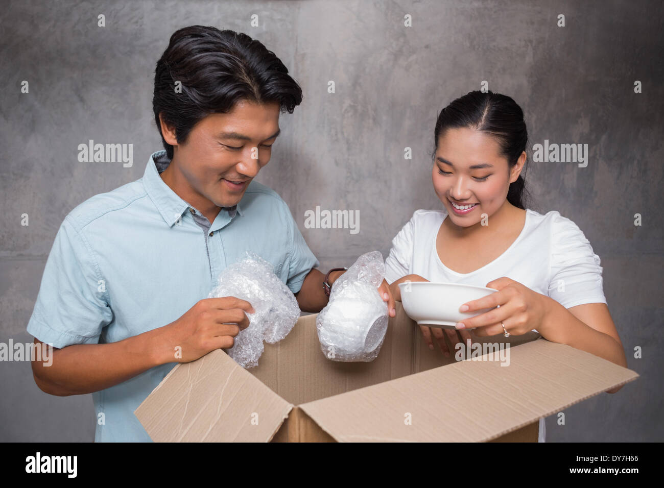 Happy couple unpacking moving boxes Stock Photo