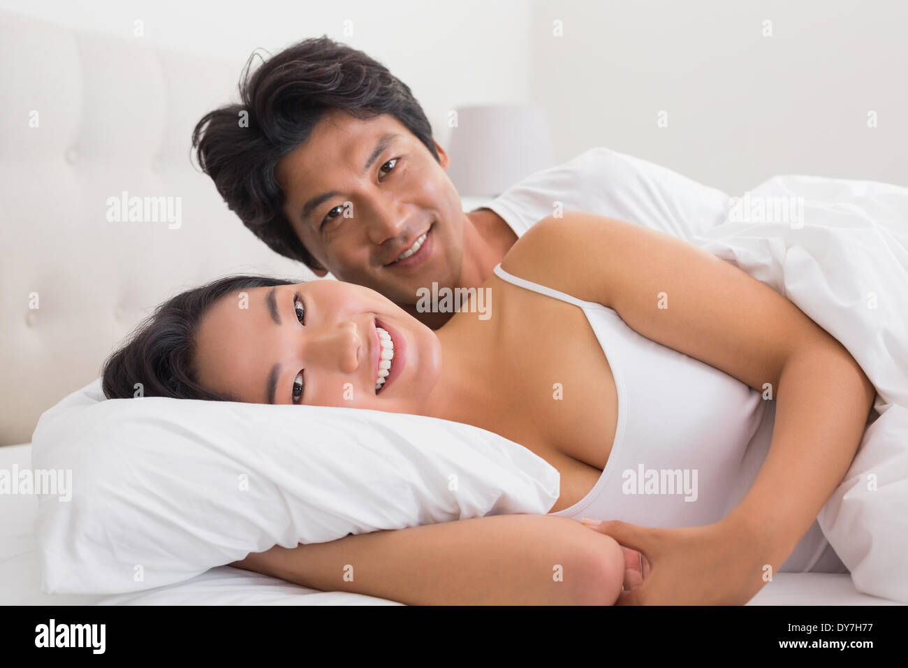 Smiling couple lying in bed Stock Photo