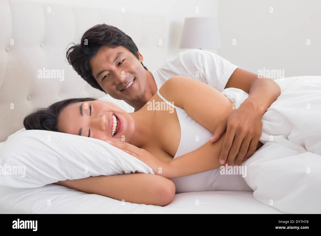 Smiling couple lying in bed Stock Photo