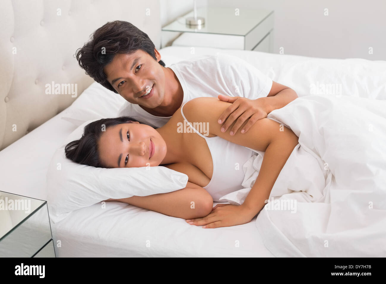 Smiling couple lying in bed Stock Photo