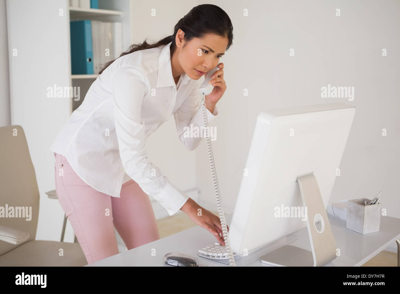 Casual businesswoman answering the phone Stock Photo