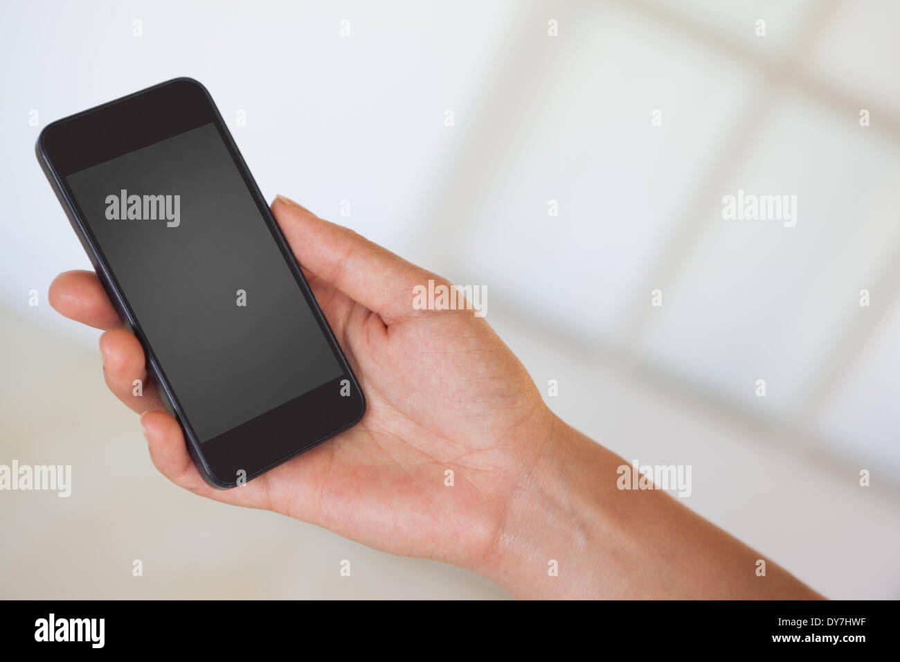 Womans hand holding black smartphone Stock Photo