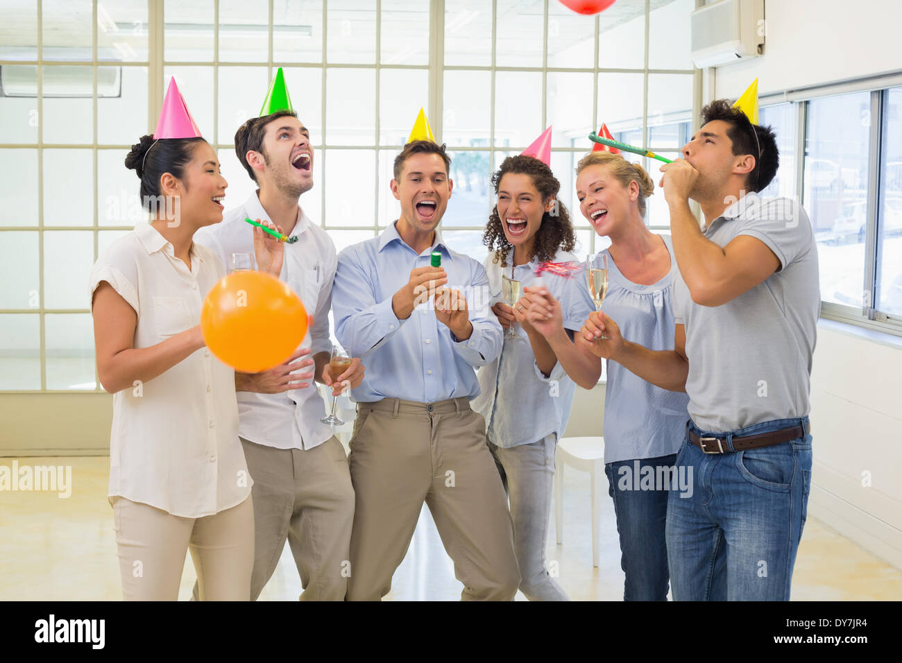 Casual business team celebrating with champagne and party poppers Stock Photo