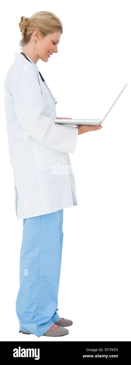 Blonde doctor in lab coat using laptop Stock Photo