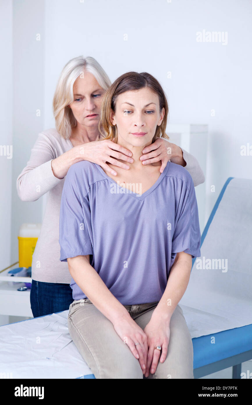 Thyroid palpation woman Stock Photo