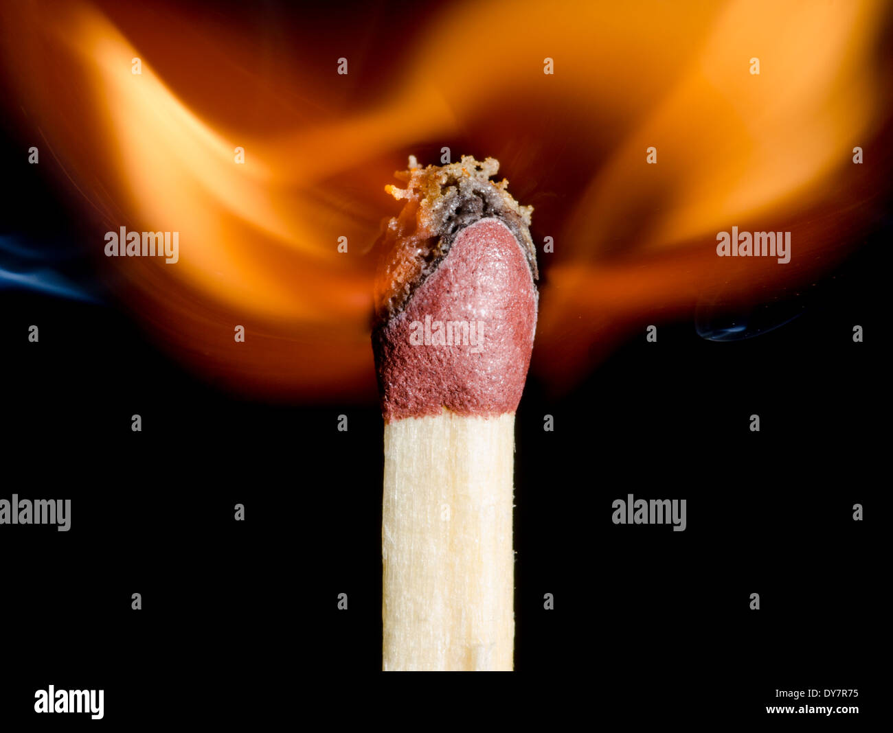 Match being lit showing flame at the point of ignition, on a black