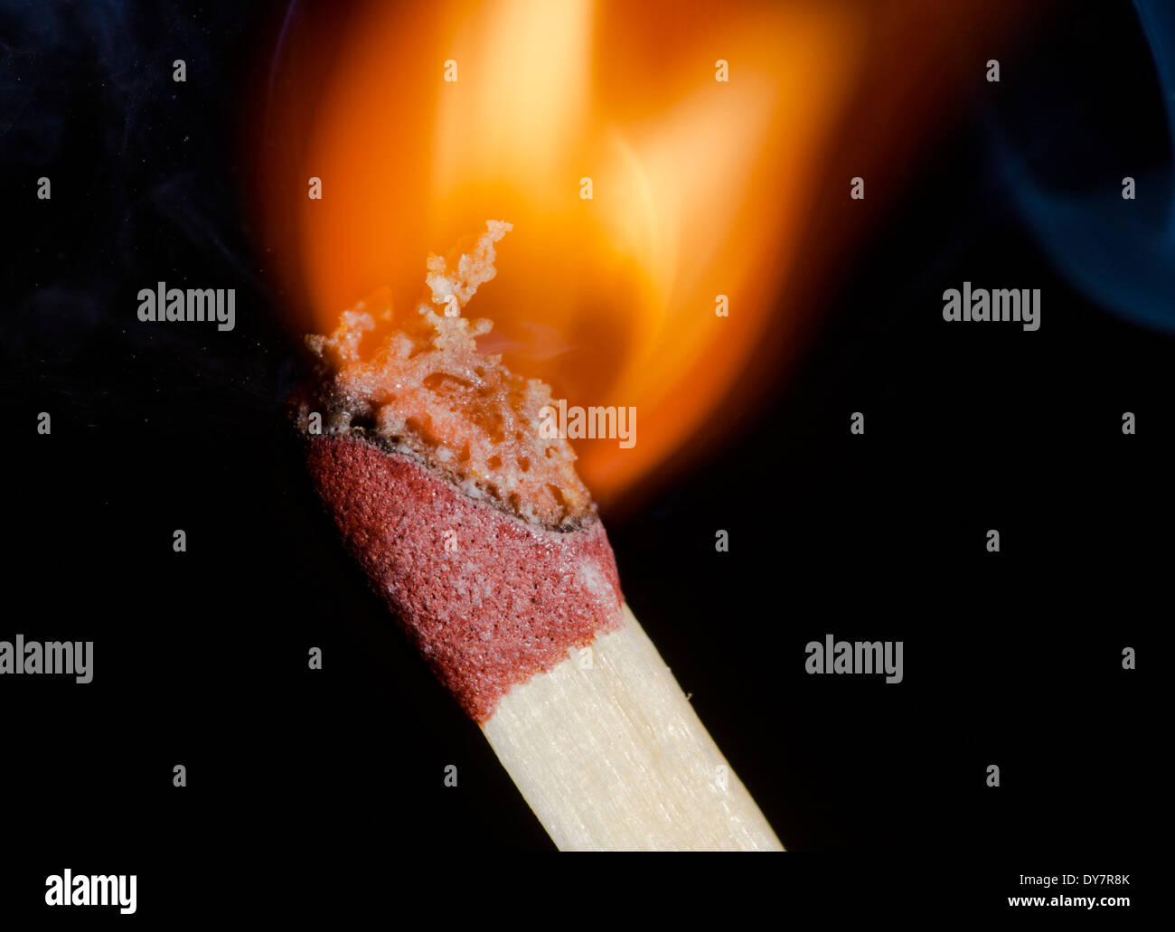 Match being lit showing flame at the point of ignition, on a black background. Burning match after being ignited. Stock Photo