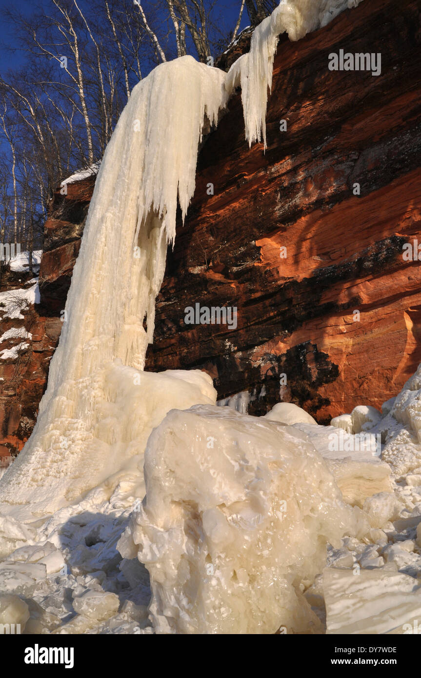 Frozen waterfall, chunks of ice and icicles hanging from red sandstone cliff, Apostle Islands National Lakeshore, Lake Superior Stock Photo