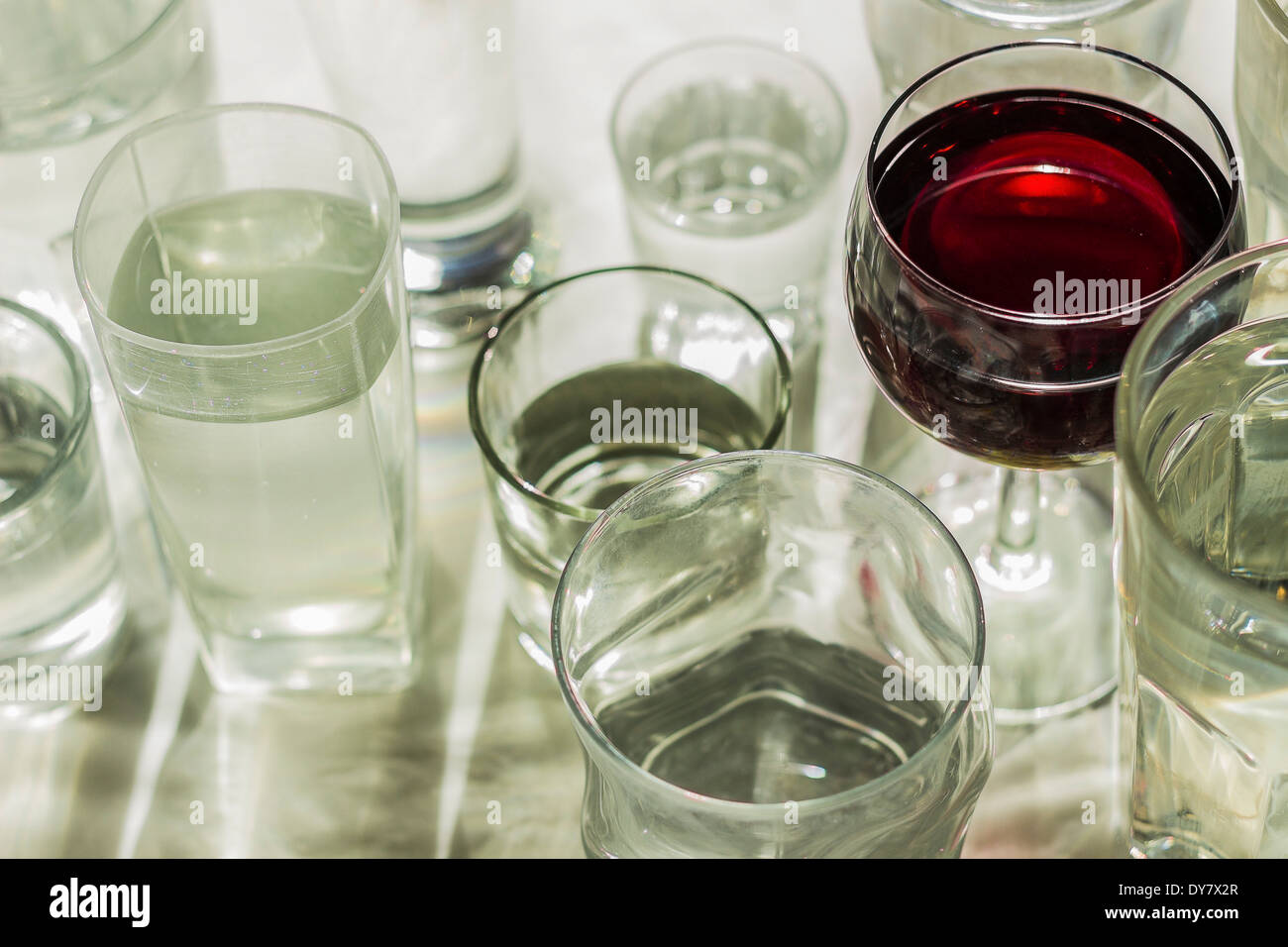 Glass of red wine in between water glasses Stock Photo Alamy