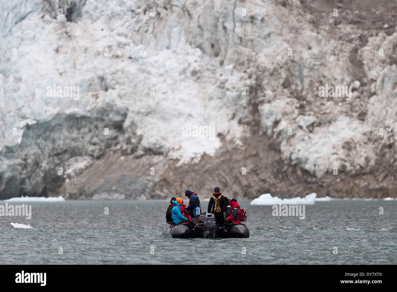 Tourists and guides in an inflatable boat, Waggonway Glacier, Magdalene Fjord, Spitsbergen Island, Svalbard Archipelago Stock Photo