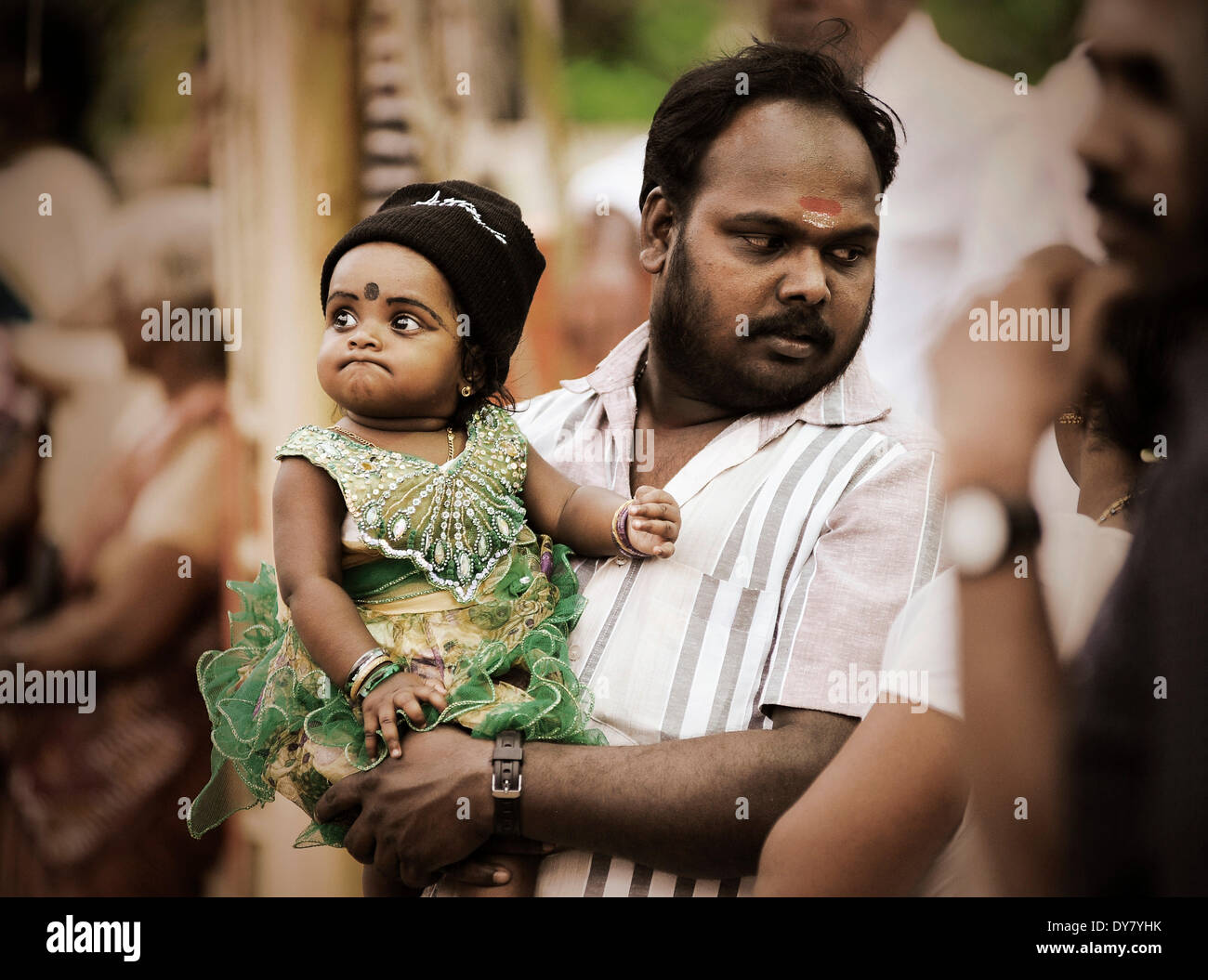 Father holding a child at a temple festival, Kerala, South India ...