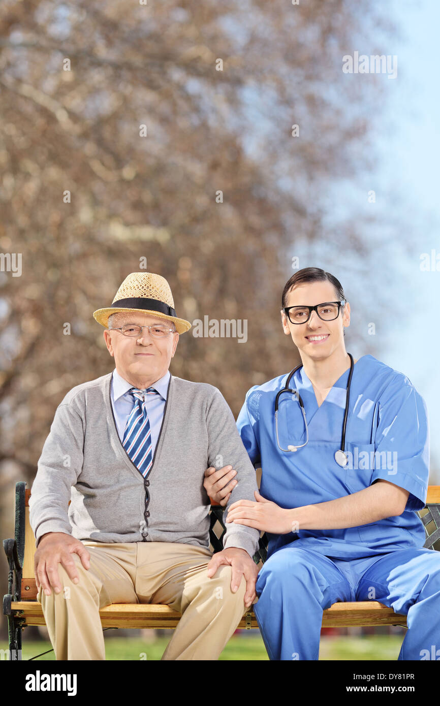 Doctor and a senior gentleman sitting in park Stock Photo